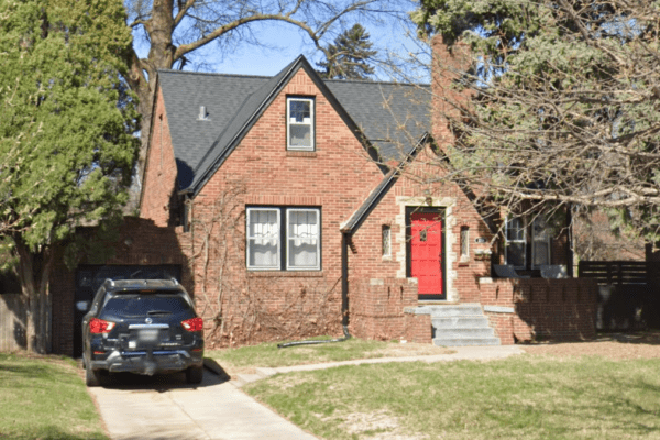 Before brick house with red door