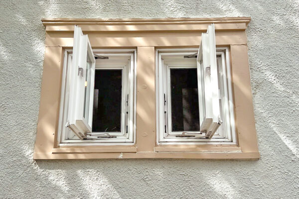 Before exterior view of 2 wide vinyl window