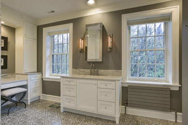Bathroom vanity surrounded by double hung windows
