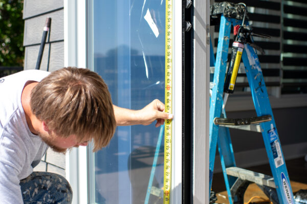 Expert Pella installer measuring a door